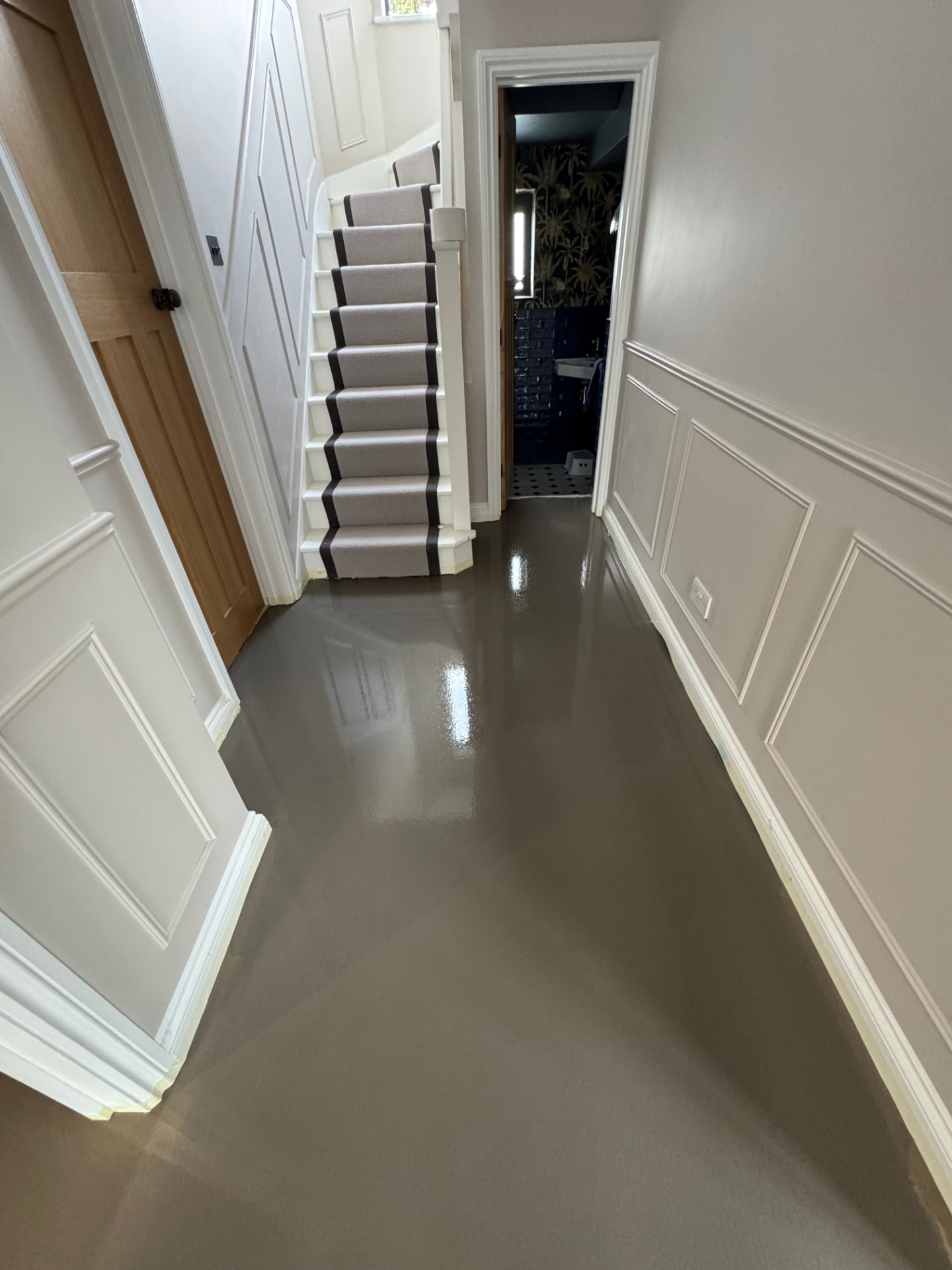 Smooth screed floor in a traditional hallway beside a staircase